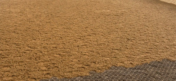 Comfortable Footing for Every Ride Indoor horse arena constructed with Paddock Slab ground reinforcement system beneath footing to provide drainage, load support, and long-term surface stability.